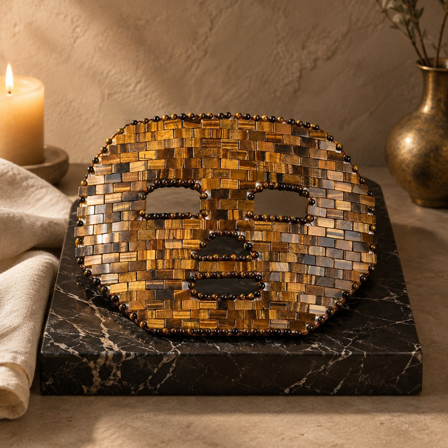 Masque de visage en mosaïque d’œil de tigre, posé sur un présentoir en marbre noir